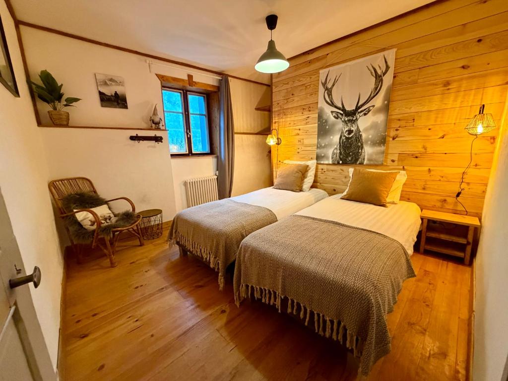 Un dormitorio con dos camas y una imagen de un ciervo. en Chalet Le Rêve, en Vénosc