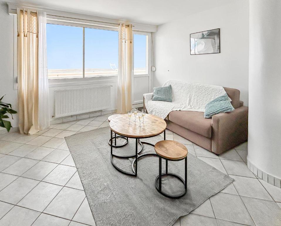 a living room with a couch and a table at Vue panoramique sur la plage, grand T2 in Dunkerque