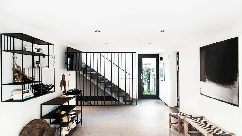 a living room with a staircase in a house at COSMOPOLITAN APARTMENTS Zürich Seefeld in Zürich