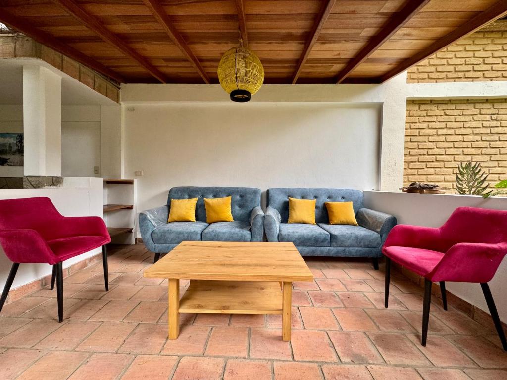 a living room with a blue couch and two red chairs at Qushi Shoncu Lodge in Huaylas