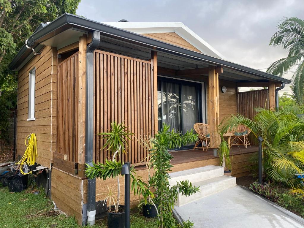 a small house with a wooden exterior at O coeur de l ouest Studio les Orangers in Saint-Paul