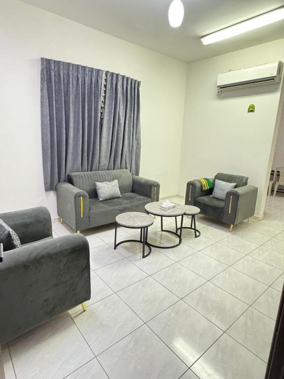 a living room with two couches and a table at شقق طرابزون المخدومة in Rumāḩ