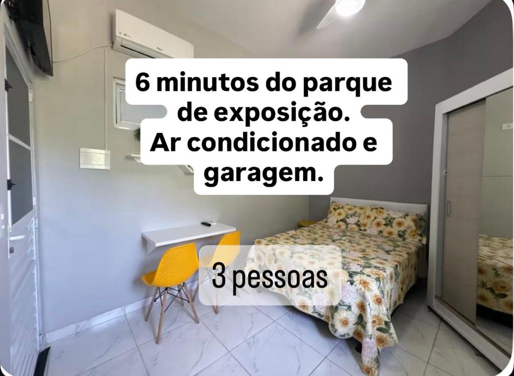 a bedroom with a bed and a yellow chair at Nº 01 Mini Apart 5 min Centro cozinha e garagem in Divinópolis