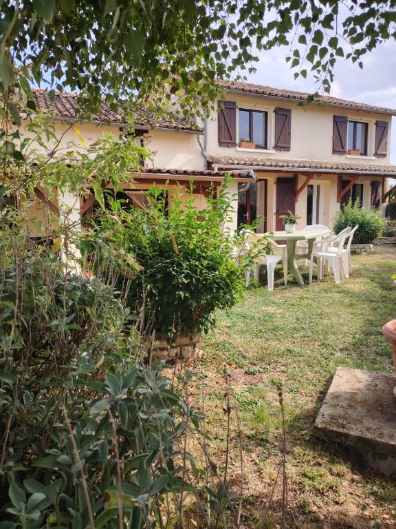 a house with a table and chairs in the yard at Le Gite de l'Alambic in Vanzay