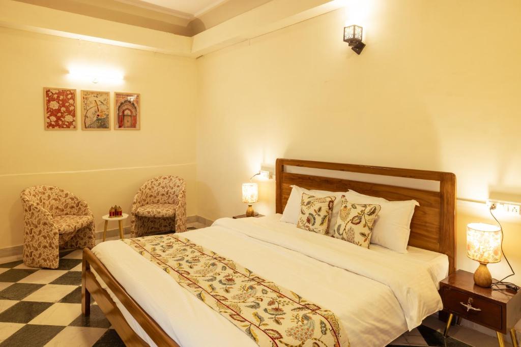 斋浦尔Ancestral Abode - A Boutique Homestay的一间有一张床和两把椅子的卧室