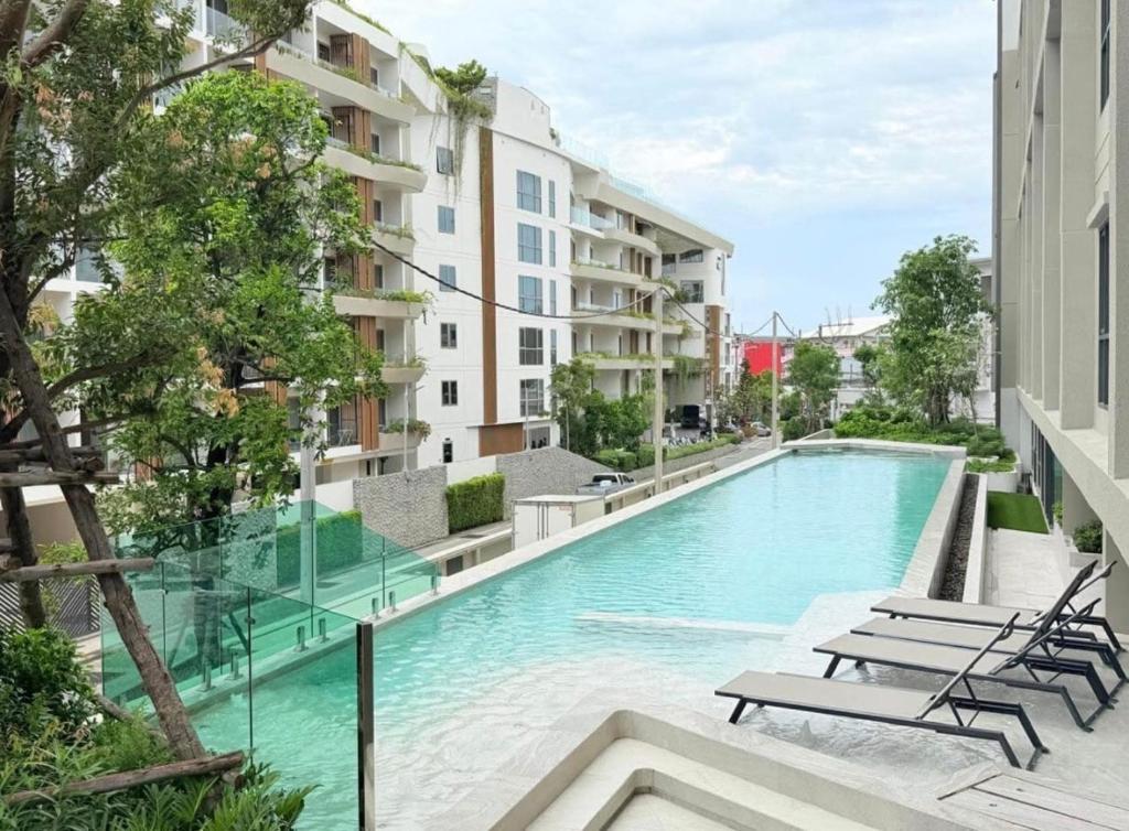 une piscine au milieu d'un immeuble dans l'établissement Space Cherngtalay 323, à Ban Thalat Choeng Thale