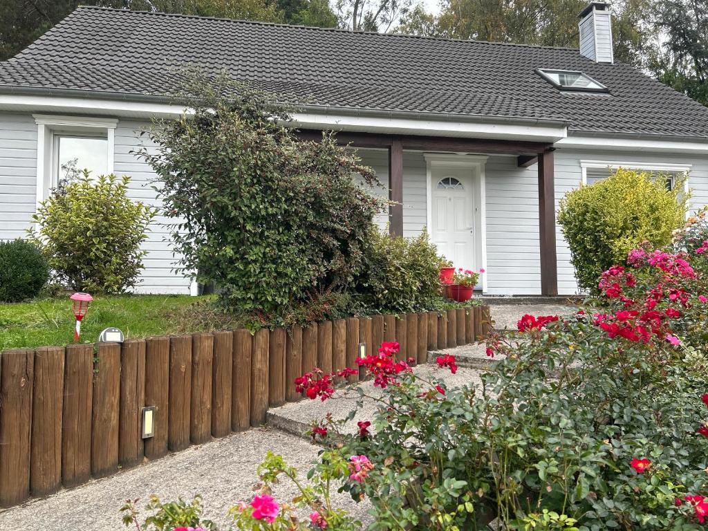a house with a fence and flowers in front of it at Chez Mamie in Hautot-sur-Mer