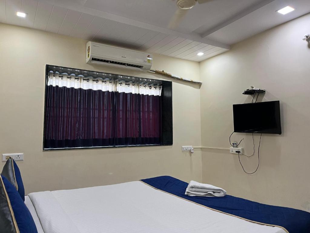 Una habitación de hospital con una cama y un televisor. en Hotel 31 Manor, en Nagpur