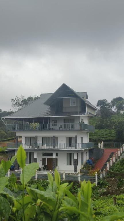 a large white building with a black roof at Laas Villa Vagamon in Vagamon