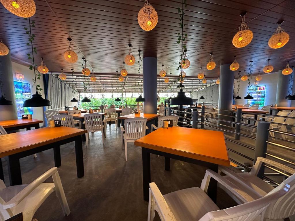 a restaurant with wooden tables and chairs and lights at Paragon Mirissa in Mirissa