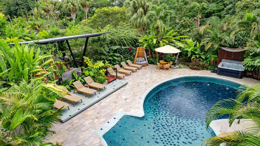 a swimming pool with chaise lounge chairs and a swimming pool at Noah's Forest Hotel by Tifakara in Fortuna