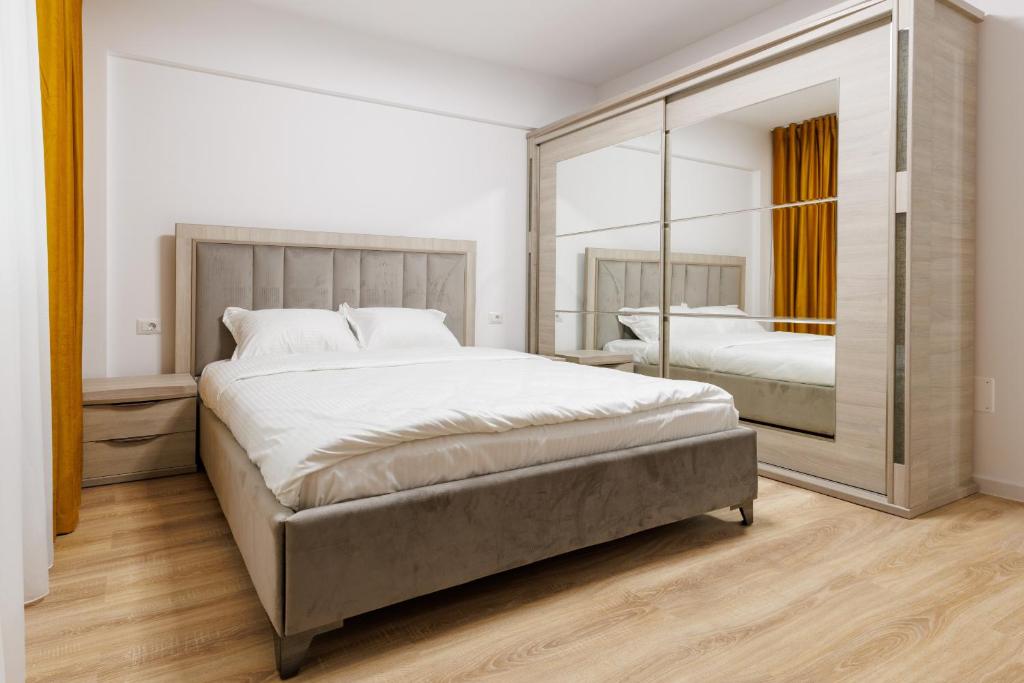 a bedroom with two beds and a large mirror at Urban Retreat 1BDR Craiova in Bordeiu