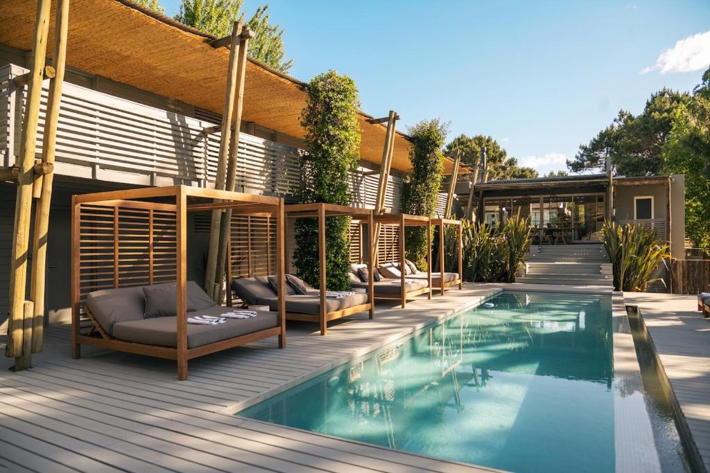 a house with a swimming pool on a wooden deck at Posada Arenas in José Ignacio