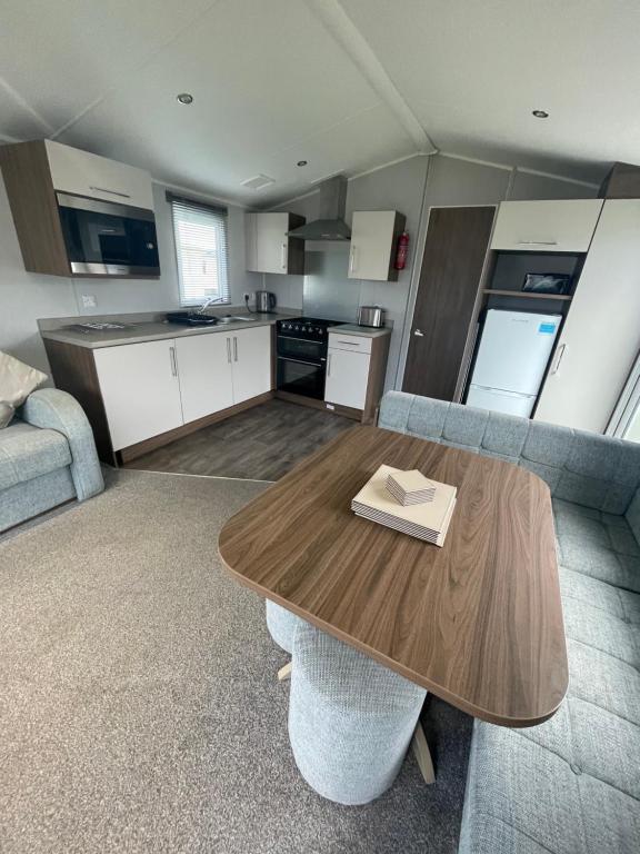 スキップシーにあるOcean retreat at Skirlington coastの木製のテーブルとキッチンのあるリビングルーム