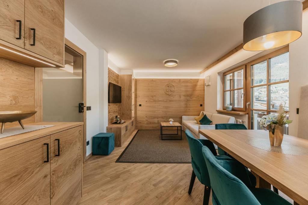 a kitchen and living room with a long table and chairs at Miraval Perathoner Andreas in Ortisei