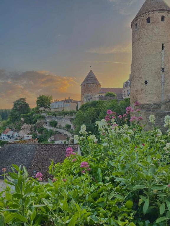 a view of a castle with flowers in the foreground at Médiévale 27 in Semur-en-Auxois