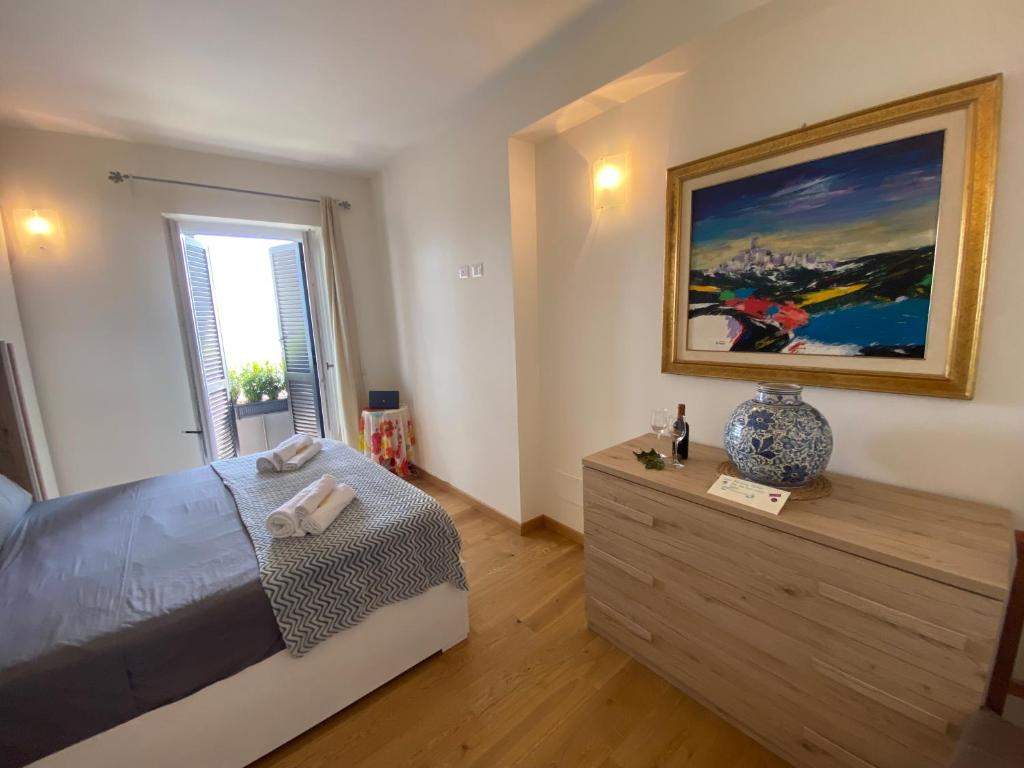 a bedroom with a bed and a painting on the wall at Trevignano Casa fronte lago in Trevignano Romano