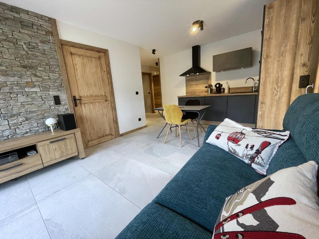 a living room with a couch and a kitchen at Appartement Haut de Gamme neuf avec deux terrasses - 6 personnes - App 102 in Saint-Sorlin-dʼArves
