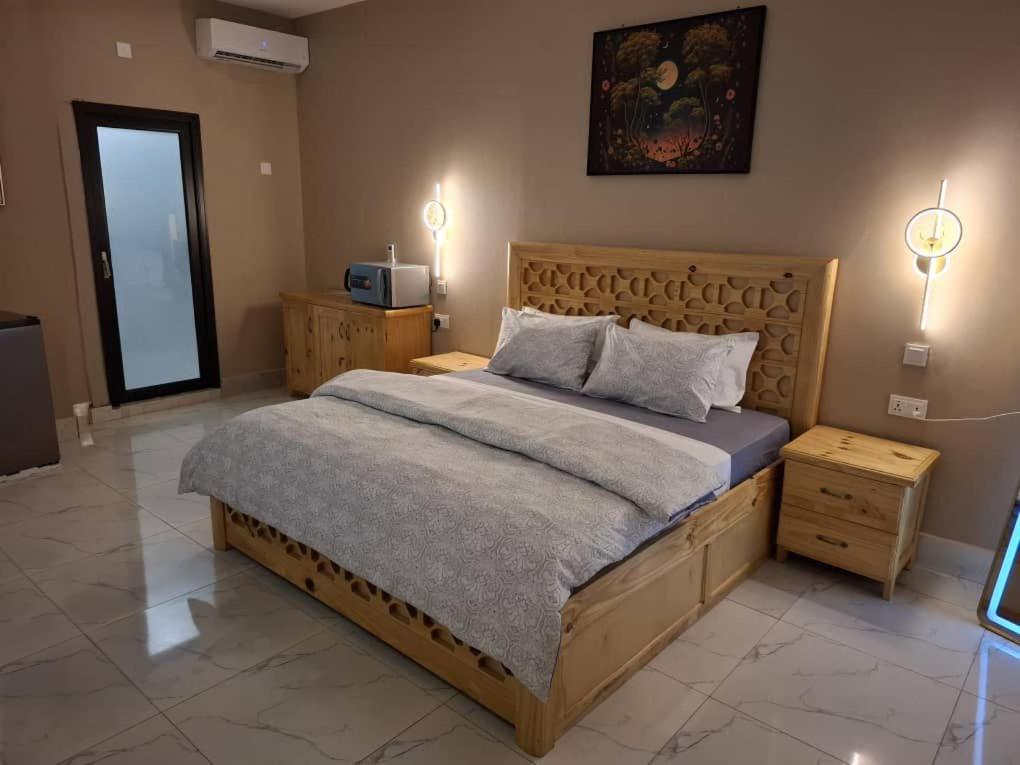 a bedroom with a large bed and two night stands at Samba's Beach Strip Apartments in Kololi