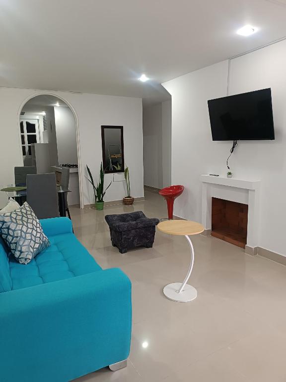 a living room with a blue couch and a tv at Apto San José in Armenia