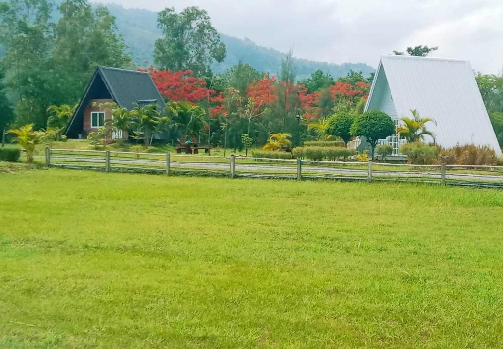 a house in a field next to a fence at The mountain deer view lodge & Hershey in Ban Mung