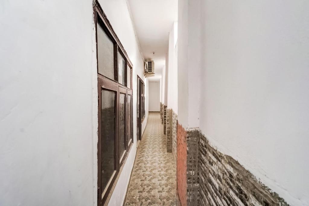 an empty hallway with white walls and a door at SPOT ON Gorav Smark in Malhour