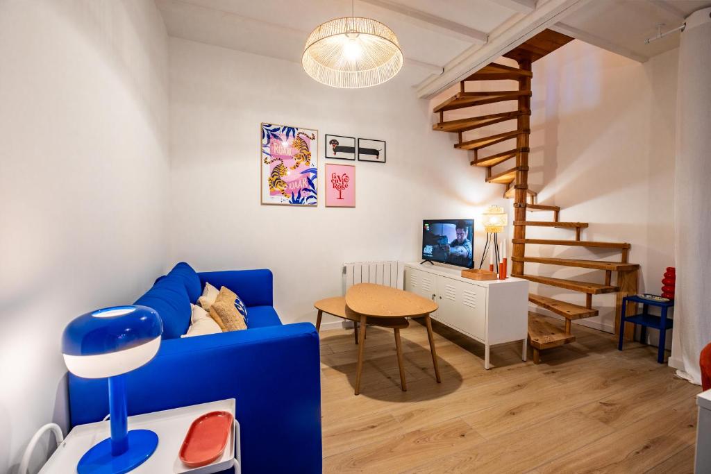 ein Wohnzimmer mit einem blauen Sofa und einem Tisch in der Unterkunft TyKalon Duplex en plein cœur historique de Dinan in La Celle-sous-Gouzon