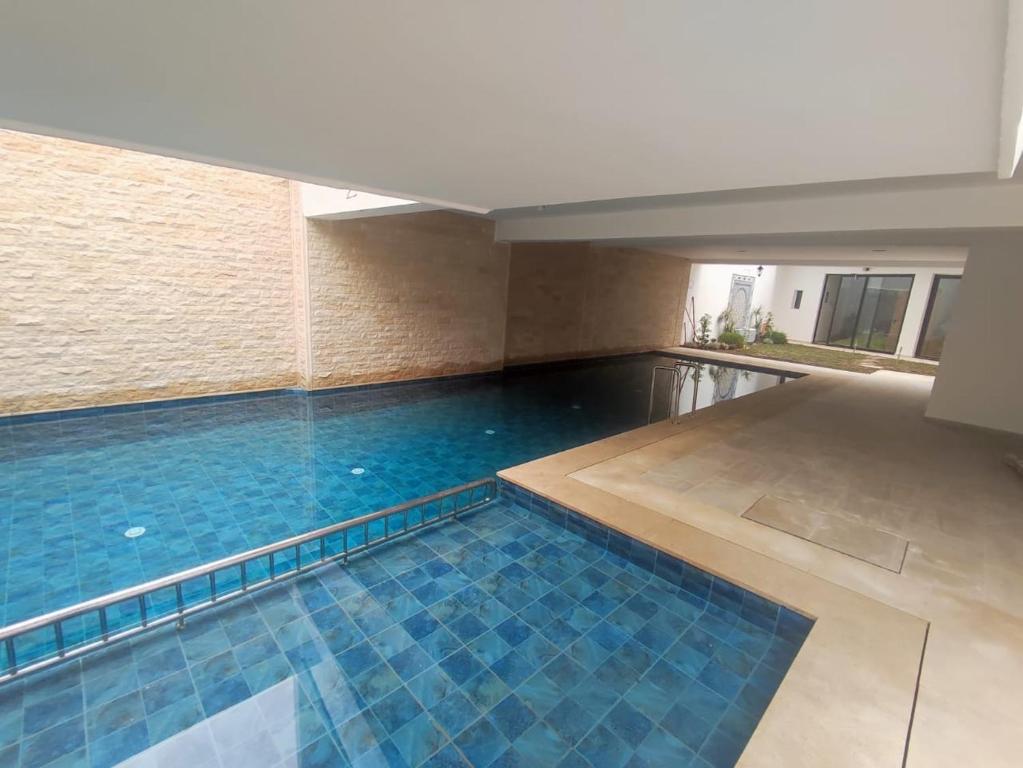 Una piscina con azulejos azules en un edificio. en Casa del mar, en Agadir nʼ Aït Sa