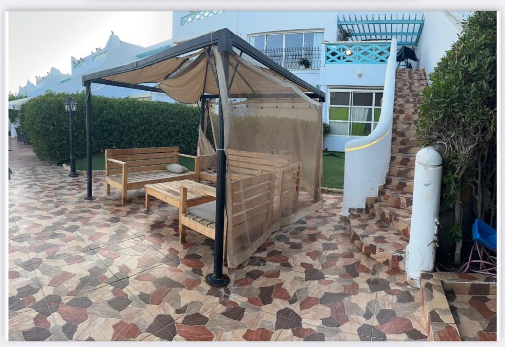 two benches under a canopy on a patio at شاليه مارفن درة العروس البرادايس in Durat  Alarous