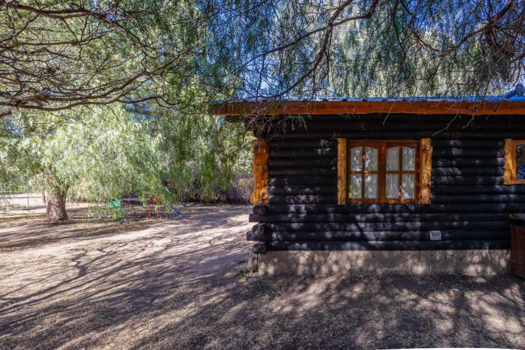 a log cabin with a window on the side of it at Cabañas rainbow in San Marcos Sierras