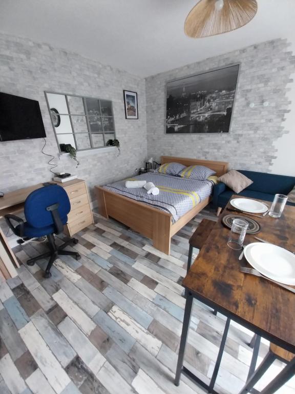 une chambre avec un lit, un bureau et une table dans l'établissement Studio Fontaine, à Niort