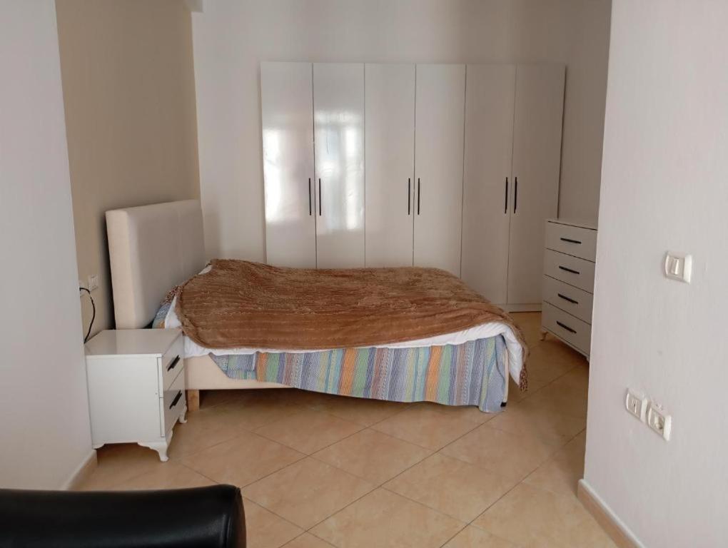 Schlafzimmer mit einem Bett und weißen Schränken in der Unterkunft Tag HOSTEL in Tirana