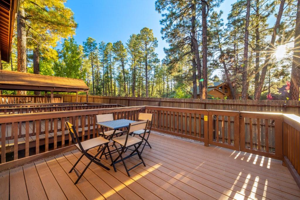 a wooden deck with a table and chairs on it at Pine-Santa Fe by Roundhouse Resort and Spa in Indian Pine