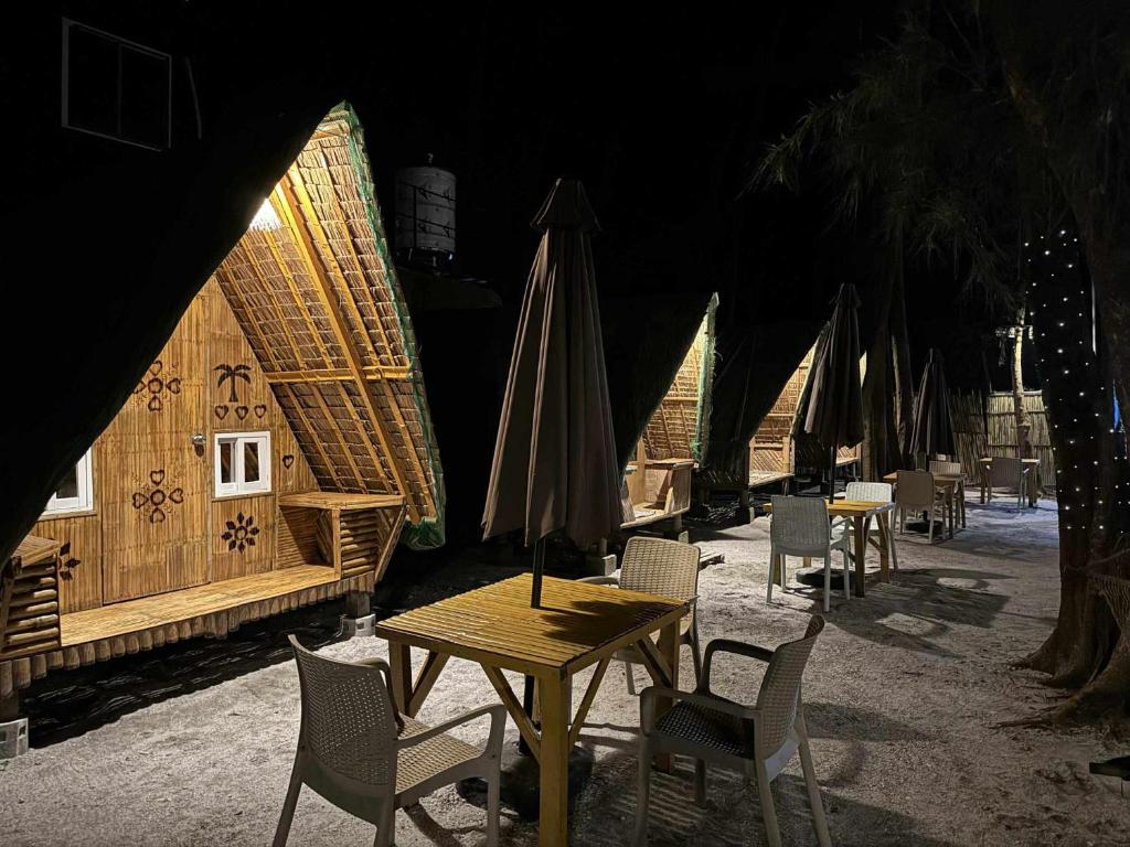 a group of tables and chairs with umbrellas at Teepee Hut Fan room in San Felipe