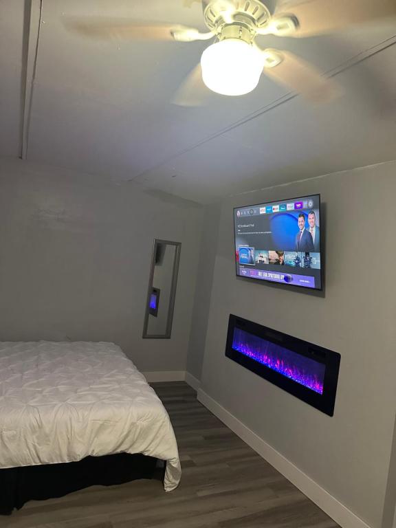 a bedroom with a bed and a tv on the wall at Guest house 7 mins From stadium in Opa-locka