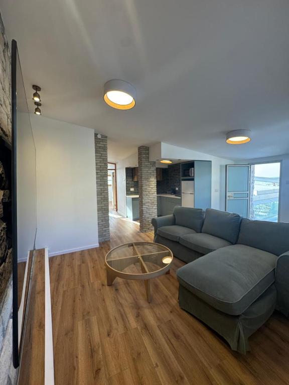 Una sala de estar con un sofá azul y una mesa de cristal. en לוריא יוקרה בעתיקה, en Safed