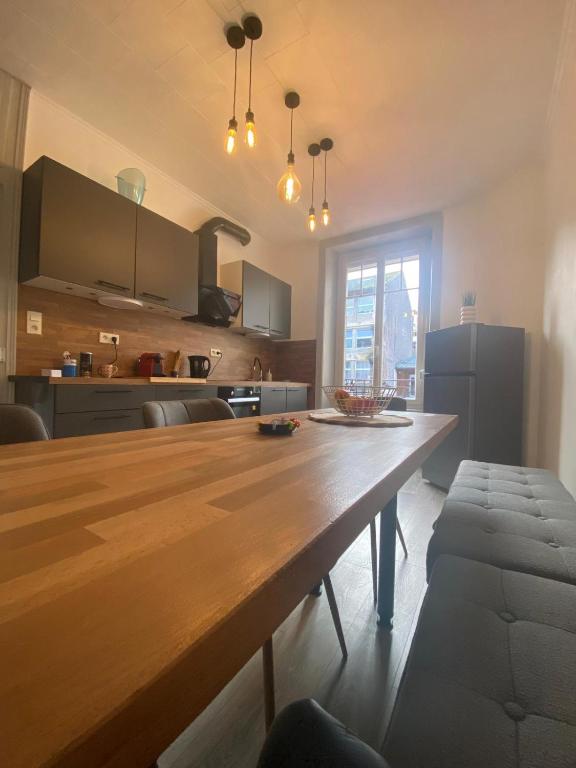 a kitchen with a large wooden table in a room at Appartement hyper-centre Épinal in Épinal