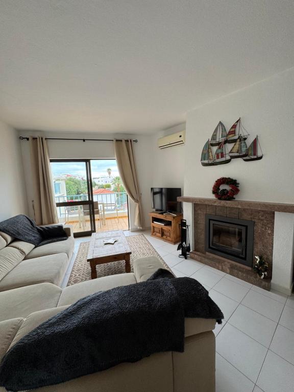 a living room with a couch and a fireplace at Casa Julio in Carvoeiro