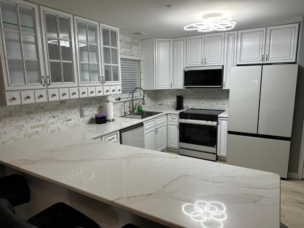 una cucina con armadi bianchi e ripiano in marmo di Spacious, Stylish and Luxurious a Brandywine