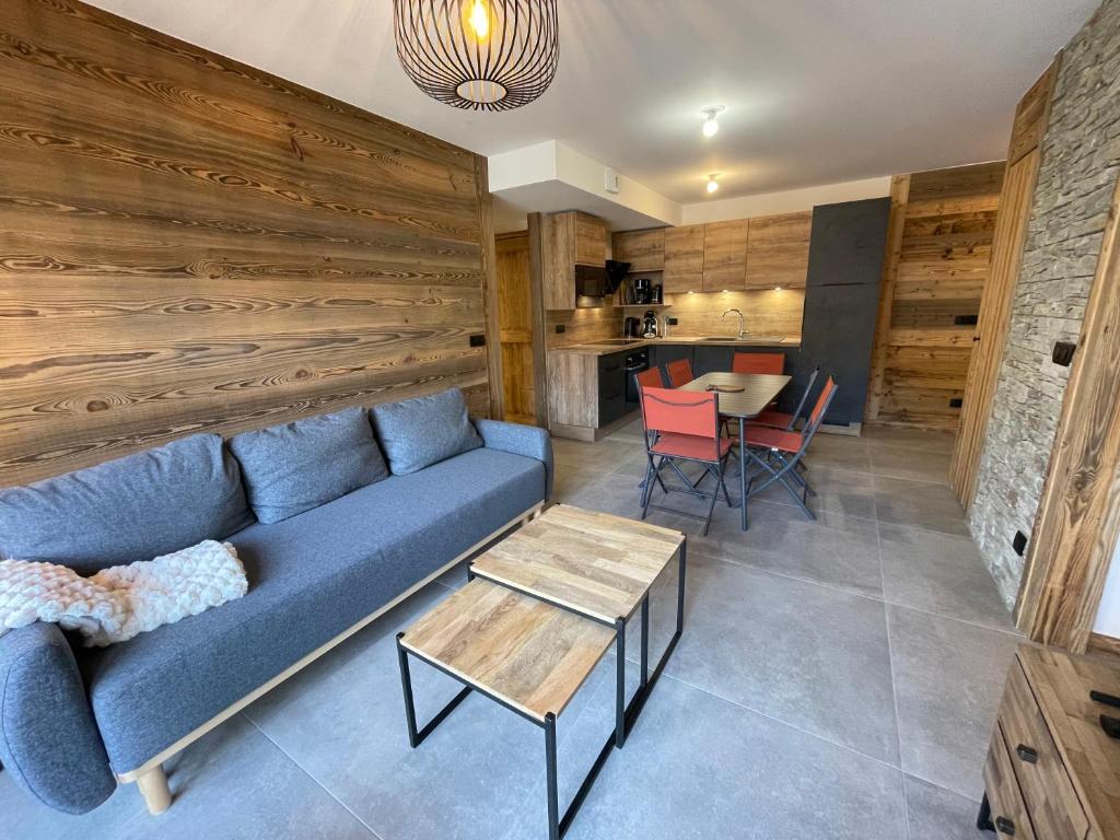 a living room with a blue couch and a table at Appartement Haut de Gamme neuf avec terrasse - 6 personnes - App 103 in Saint-Sorlin-dʼArves