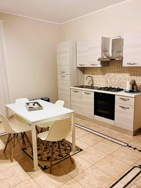 cocina con mesa blanca y sillas en House in Cave, en Massafra