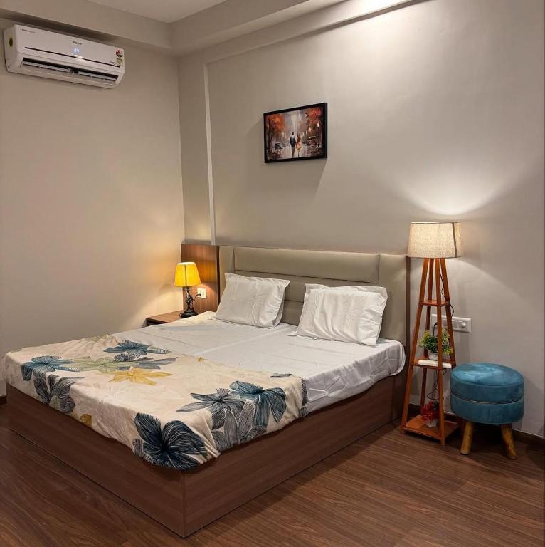 a bedroom with a bed and a desk with a lamp at paradise stay in Greater Noida
