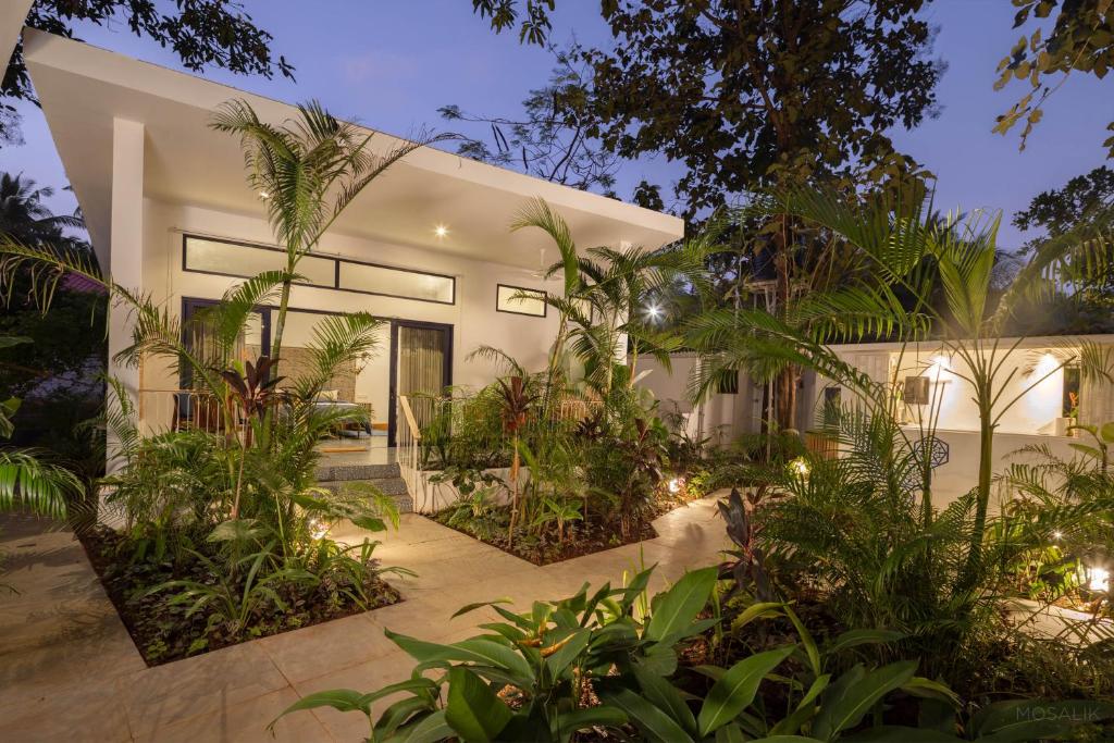 a house with a lot of plants in front of it at Jaali Blue in Canacona