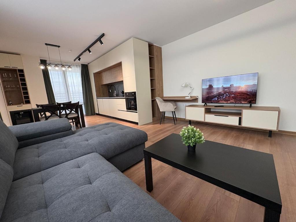a living room with a couch and a tv at New Urban Stay Airport city center metro access in Sofia
