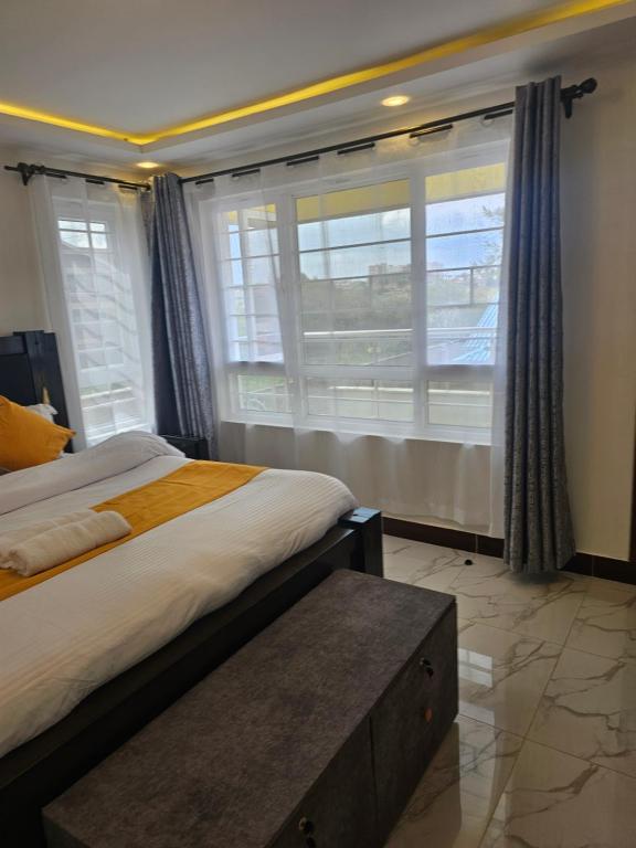 une chambre avec deux lits et une grande fenêtre dans l'établissement Twin Paradise Homes, à Nairobi