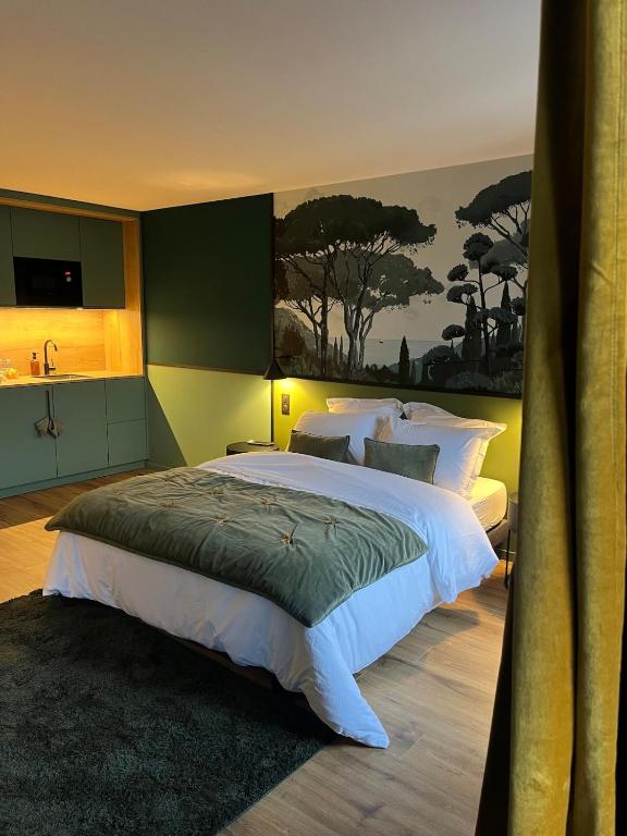 a bedroom with a large bed and a painting on the wall at Studios et Appartement meublé de tourisme in Altkirch