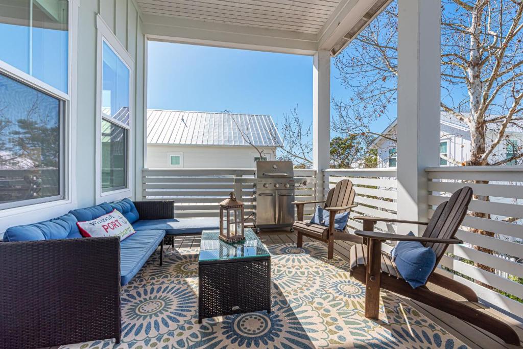 eine abgeschirmte Veranda mit einem blauen Sofa und Stühlen in der Unterkunft Vitamin Sea in Inlet Beach