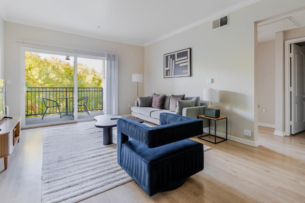 ein Wohnzimmer mit einer Couch und einem Sessel in der Unterkunft Blueground Santa Clara pool nr Central Park SFO-2067 in Agnew