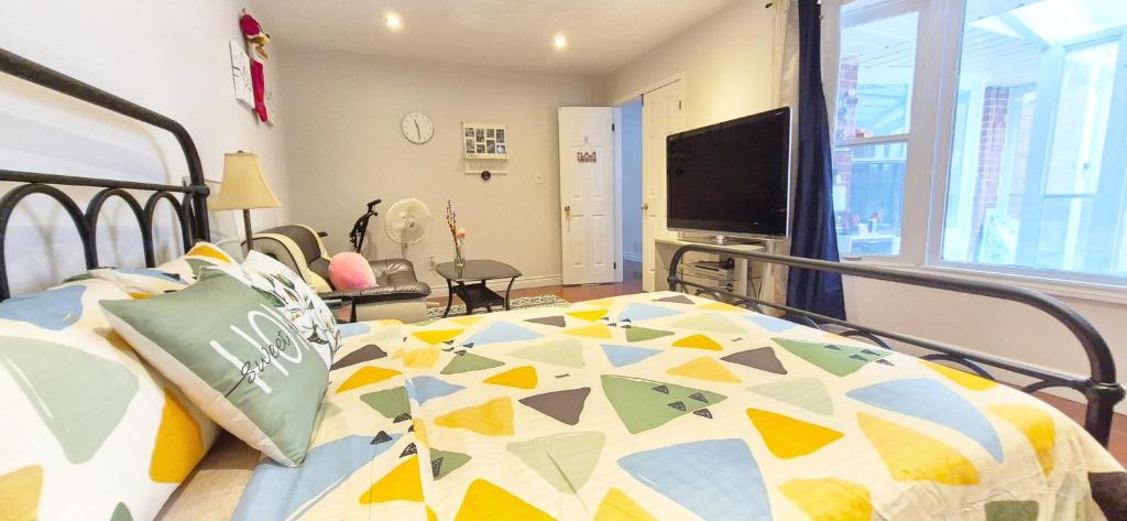 a bedroom with a bed with a colorful comforter at Mainfloor Spacious Room in Toronto in Toronto