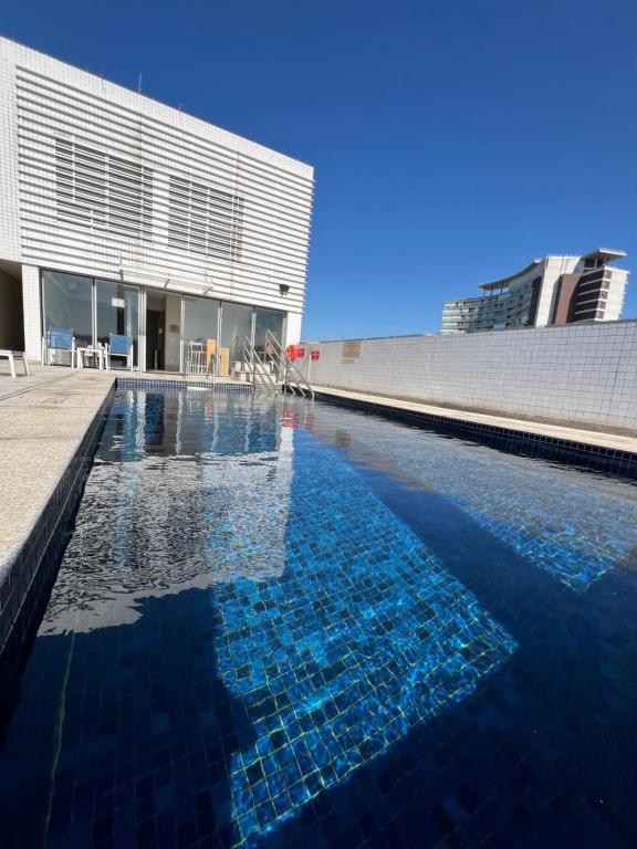 サントスにあるFlats na praia com AC, piscina, sauna e academia!の建物の前のプール